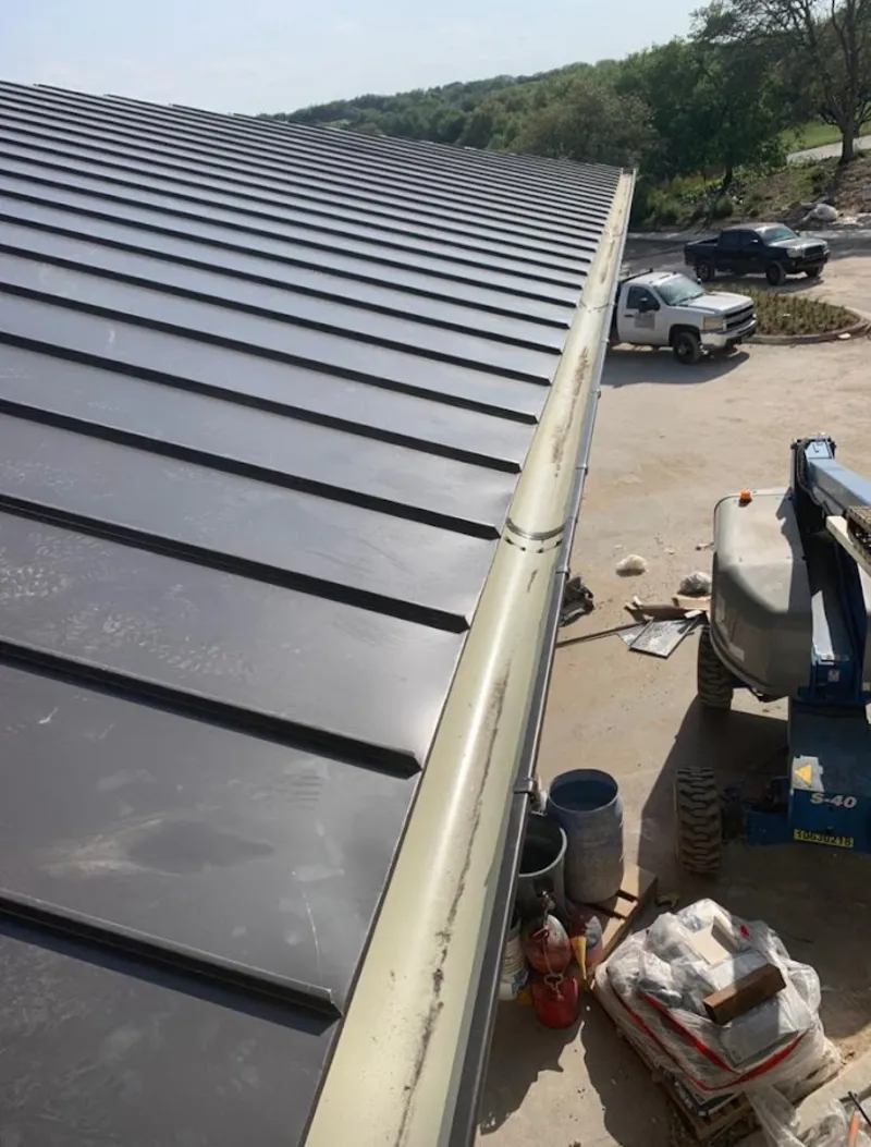 Standing seam panel and gutter detail on a metal roofing jobsite in Chena Ridge